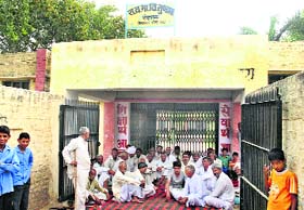 Residents of Sundana village in Rohtak district on a dharna outside a government school