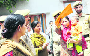 Shabnam carrying her son argues with policemen to enter the Relief Commissioners office in Jammu on Monday.
