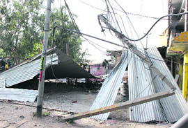 An electricity pole that fell on a tin shelter at the Gangyal road during the Sunday nights storm in Jammu.