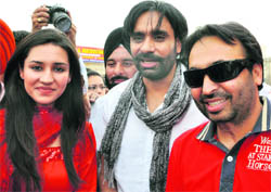 Punjabi singer-actor Babbu Mann flanked by comedian Bhagwant Mann and actress Mohitinder Bawa during the premier of his film in Ludhiana