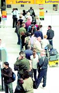 Travellers queue up at an airline check-in counter at Nice International Airport in France on Monday