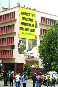 Activists of Greenpeace hang a banner from the rooftop of CSIR building to protest against the GM Food Bill in New Delhi on Tuesday.