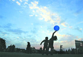 Children play with a ball on a cloudy evening in Shimla. 