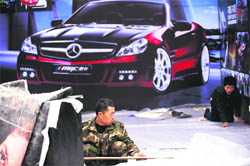 A worker makes an exhibition space at the venue of the Beijing Auto Show near the capital's airport on Wednesday. Nearly 1,000 cars will be on display at the show when it opens on April 23 with 89 models making their global debut as manufacturers seek a bigger piece of a market that sped past America last year to become the world's biggest.
