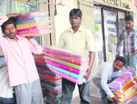 Chandigarh Municipal Corporation employees take away items seized during an enforcement drive at the Sector 19-D market on Wednesday.