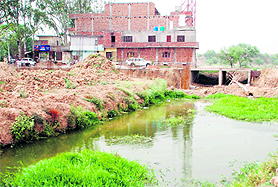 Illegal structures under construction on the bed of Sirhind choe.