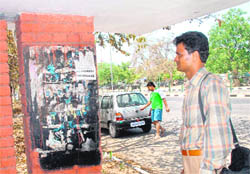 A helpless passenger takes a look at the defaced timetable at a Sector 35 bus queue shelter.
