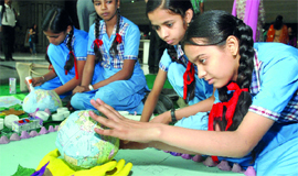 Schoolchildren make a globe out of waste material in Waste to Craft competition on World Earth day in New Delhi on Thursday.