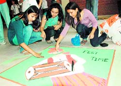 Students draw a rangoli at the Institute of Management Studies during their annual function in Dehradun 