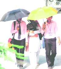 Girl students protect themselves from the sun as they come out of their examination centre in Haridwar