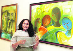 Panchkula-based Neenu Vij with her paintings at a solo art exhibition in Gurgaon. 
