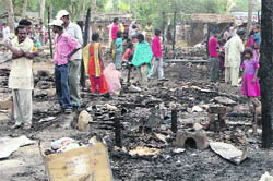 Shanties destroyed in a fire and (inset) a woman weeps after the loss suffered by her family. 