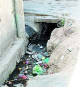 Water supply pipes pass through an open drain in Gali Hatimtai in Ward 44.