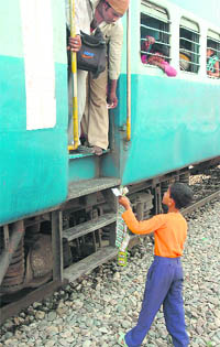 Despite a ban, a minor sells tobacco items to a passenger at the Channi Himmat level crossing in Jammu.