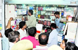 Officials of the raiding party check mobile sets at a shop in Gur Mandi, Ludhiana, on Saturday. A Tribune photograph