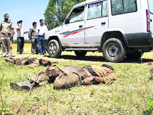 Policemen inspect the bodies of militants killed in an encounter at Ratrawan village in Gurdaspur district on Sunday.