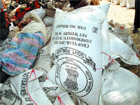 Wheat bags with national emblem printed on them lie near a dump of garbage