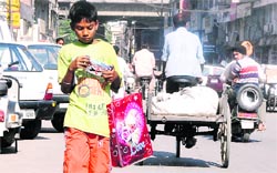 Akash Kumar (13) walks down city lanes in search of buyers for his wares in Ludhiana.