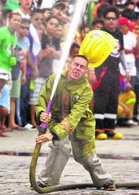 The helmet of a volunteer fireman is taken off his head by a high-pressured water cannon as he loses control during a volunteer firemen's competition called in Manila on Sunday