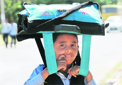 A schoolgirl uses her bag to shield herself from the sun on a hot Monday afternoon at Sector 26, Chandigarh.