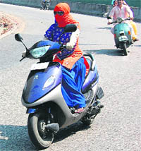 A girl covers her face to shield herself from the scorching heat in Jammu on Monday.
