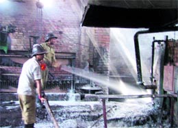 Fire fighters douse the flames at Mahavir Steel on Jalandhar bypass in Ludhiana on Monday. Photo: Inderjeet Verma
