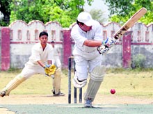 A batsman plays a shot during a match of the CGEWCC Cricket Tournament at Survey Grounds in Dehradun 