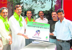 Uttarakhand Agriculture Minister Trivender Singh Rawat honours three shopkeepers with green certificates at Jakhan in Dehradun