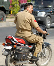 With no helmet on, a policeman rides a motorcycle with no registration number in Jalandhar.