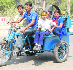 A sugarcane juice seller returns home with members of his family after exhausting his stock in Jalandhar on Wednesday.