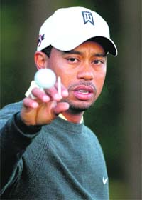 Tiger Woods catches a ball as he warms up on the practice range during the pro-am for the Quail Hollow Championship at Quail Hollow Country Club