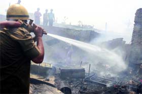 A fire official at work in Taimoor Nagar, Maharani Bagh, New Delhi on Thursday.
