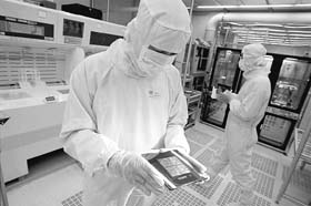 Employees work at a Taiwan Semiconductor Manufacturing Company Ltd (TSMC) 8-Inch Wafer Fab laboratory in Hsinchu