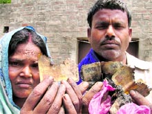 Sat Narayan and his wife show burnt currency notes at Hussainpura village. Tribune photo: Inderjit Verma