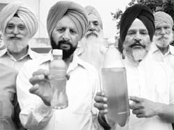 Residents of Phase XI show muddy drinking water in Mohali. 
