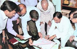 Chief Minister Ramesh Pokhriyal Nishank fills information about his family in census papers marking the start of census operations in the state on Saturday.