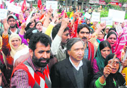 CPM state secretary MY Tarigami, along with ASHA workers, holds a protest march to Lal Chowk on May Day in Srinagar on Saturday. ASHA workers were demanding regularisation of their services and increase in wages