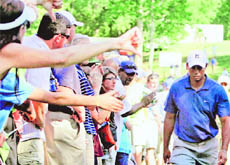 A woman (L) shows a thumbs down sign to  Tiger Woods after he finished his round at Quail Hollow Country Club on Friday.