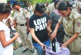 Police personnel check visitors at Sarojini Nagar Market in New Delhi on Sunday. 