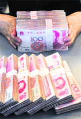 An employee counts yuan banknotes at a branch of the Pudong Development Bank in Hefei, Anhui province on Monday. China on Sunday raised the proportion of deposits that lenders must keep in reserve at the central bank, another step in its months-old campaign to mop up excess cash in the economy at a time when inflation is on the rise.