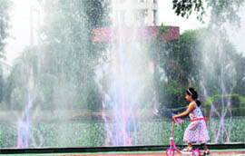 With the mercury shotting up, this girl seeks to enjoy a ride on a tricycle near a fountain at the Karna Lake tourist complex in Karnal.