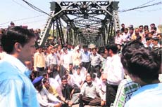 Members of the Rajouri-Poonch United Front block the Abdullah Bridge in Rajouri on Monday. 