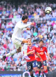 Real Madrid's Cristiano Ronaldo scores his team's third goal against Osasuna during the Spanish league at the Santiago Bernabeu stadium in Madrid, on Sunday.