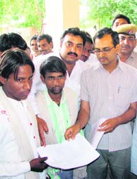 Additional DC Ashok Garg hands over a job letter to one of the sons of Tara Chand at the mini-secretariat in Hisar
