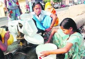 SUMMER SORROWS: Residents fetch water from a leaking water supply pipe in Jammu