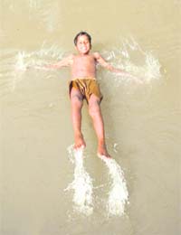 COOLING OFF: This boy dives into a canal to get some respite from the scorching sun near Muthi Camp in Jammu