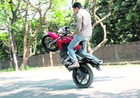A boy performs stunts on his bike in Dehradun on Wednesday.