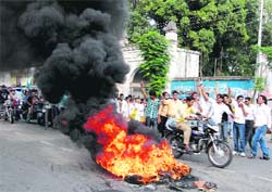 ABVP activists burn tyres as mark of protest against the Rishikul management in Haridwar on Wednesday.