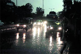 Vehicles move slowly with headlights on amidst heavy rain in Jammu on Wednesday. Tribune photo: Anand Sharma