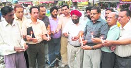 Members of the Punjabi Sangathan hold candles in memory of those killed in Mumbai terrorist attack in Dehradun on Thursday.